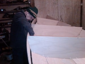 Canoe building. Seat support being stitched in place